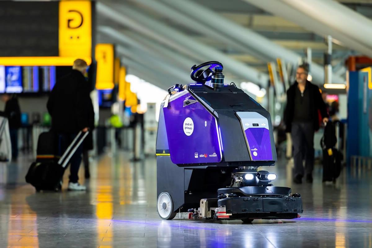 身穿紫色衣服的机器人清洁工在希思罗机场自动巡逻