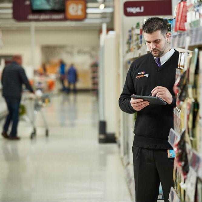 塞恩斯伯里超市的一名米蒂保安使用移动报告设备